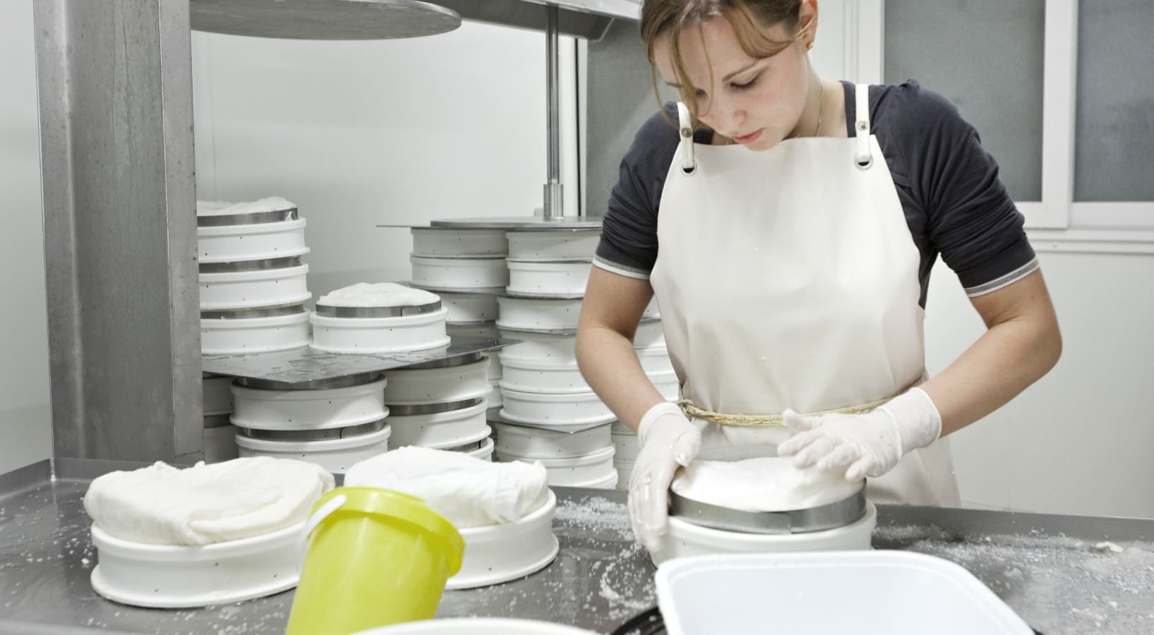 Jeune femme en pleine fabrication de Saint-Nectaire AOP